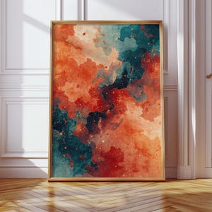 May include: A framed abstract art print featuring a watercolor design. The artwork showcases a blend of orange, teal, and red hues, with a speckled, cloudy effect. The frame is a light brown color, and the print is displayed on a wooden floor.