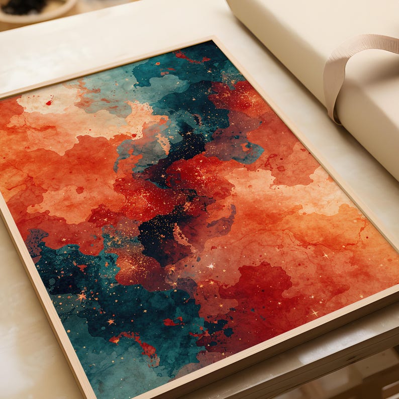 May include: A framed abstract art print featuring a watercolor design. The artwork showcases a blend of orange, teal, and dark blue hues, with speckled gold accents. The print is set within a light-colored wooden frame, creating a modern aesthetic.