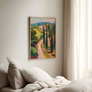 Puede incluir: Una pintura enmarcada de un paisaje con un camino sinuoso que lleva a la cima de una colina. El camino est&aacute; bordeado de &aacute;rboles altos y delgados y hay una peque&ntilde;a casa en la distancia. La pintura est&aacute; realizada en un estilo vibrante con tonos de verde, amarillo, azul y rosa.