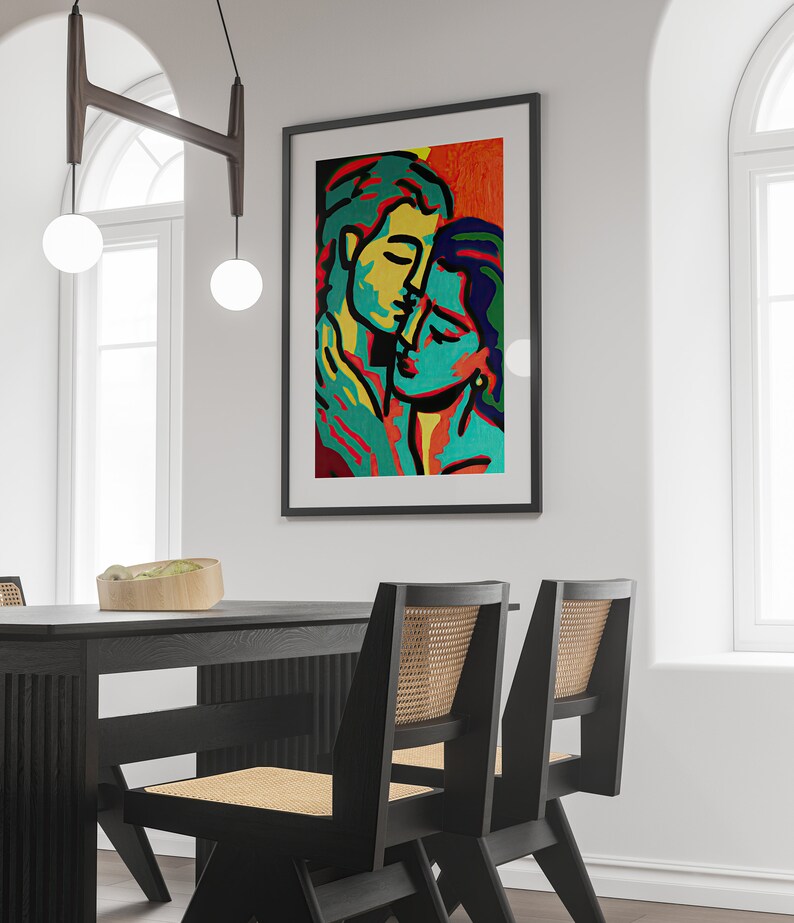 K&ouml;nnte beinhalten: Ein gerahmtes abstraktes Gem&auml;lde von zwei Personen, die sich umarmen. Das Gem&auml;lde ist in einem kr&auml;ftigen Stil mit leuchtenden Farben gehalten, darunter Gelb, Gr&uuml;n, Blau und Orange.