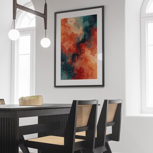 May include: A framed abstract art print with a watercolor effect. The artwork features a blend of orange, red, and teal hues, creating a dynamic and colorful composition. The print is displayed on a white wall, enhancing the vibrant colors.