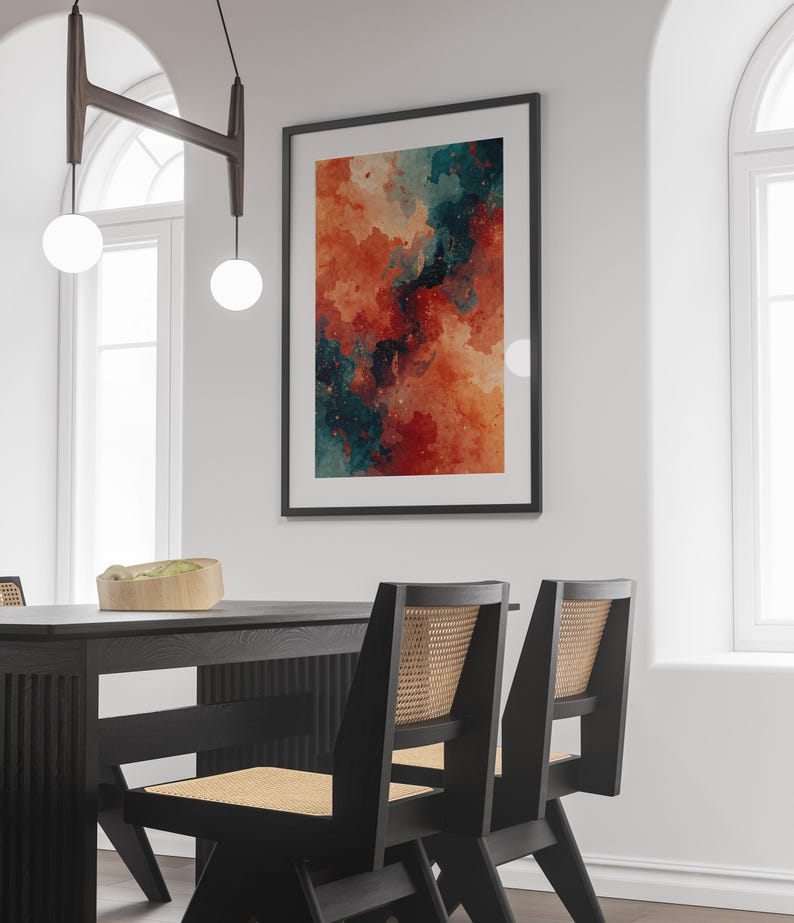 May include: A framed abstract art print with a watercolor effect. The artwork features a blend of orange, red, and teal hues, creating a dynamic and colorful composition. The print is displayed on a white wall, enhancing the vibrant colors.