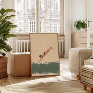May include: A framed illustration of a person diving into a wave. The illustration is in a minimalist style with a beige background and green and white waves.