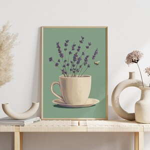 May include: A framed illustration of a white teacup and saucer with a bouquet of purple lavender flowers inside. A small bee flies above the flowers against a green background.