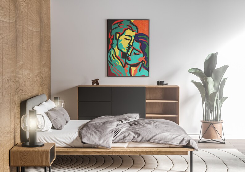 K&ouml;nnte beinhalten: Ein Schlafzimmer-Interieur mit einem Bett, einer Kommode, einer Pflanze und einem gerahmten abstrakten Gem&auml;lde von zwei sich umarmenden Personen. Das Gem&auml;lde ist in einem schwarzen Rahmen und zeigt leuchtende Farben, darunter Rot, Orange, Gelb, Gr&uuml;n und Blau.