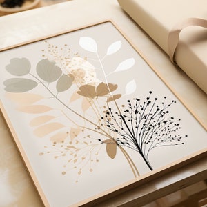 May include: A framed print with a botanical illustration of stylized leaves and flowers in shades of beige, brown, and black on a light beige background.