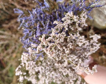May include: A bouquet of dried flowers with purple and white blooms. The flowers are arranged in a loose, natural style.