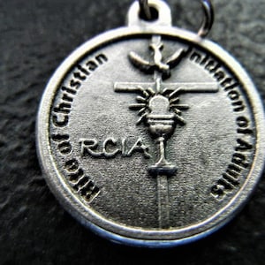 May include: Silver pendant with the inscription "Initiation of Adults to Christian Life" and the acronym "RCIA" around a stylized cross with a chalice and dove.