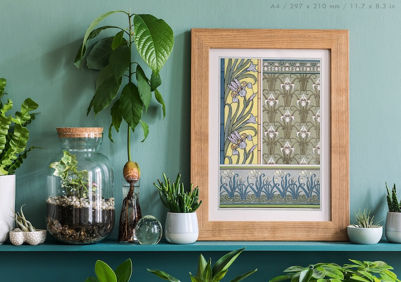 May include: A framed print of a vintage botanical illustration featuring a repeating pattern of stylized iris flowers in shades of blue, green, and yellow. The print is displayed on a shelf with various potted plants.