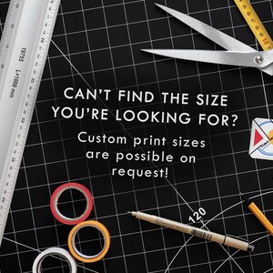 May include: A black cutting mat with a ruler, scissors, tape, and a pencil. The text "CAN'T FIND THE SIZE YOU'RE LOOKING FOR? Custom print sizes are possible on request!" is written on the mat.