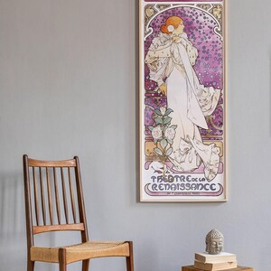 May include: A vintage poster featuring a woman in a white dress with a floral design. The poster is framed in wood and has the text "LA DAME AUX CAMELIAS SARAH BERNHARDT THEATRE DE LA RENAISSANCE" printed on it.