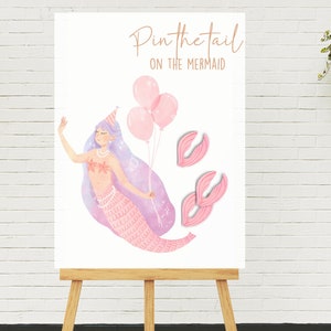 May include: A pink mermaid with a party hat and balloons, holding a string of pearls.  Two pink mermaid tails are on the white background.  The text "Pin the tail on the mermaid" is at the top of the image.
