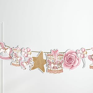 May include: Pink and gold carousel horse, rocking horse, star, rose, and balloons garland banner. The garland is made of paper and is perfect for a baby shower or birthday party.