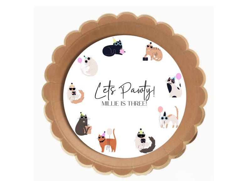 Pu&ograve; includere: Piatto di carta marrone con un cerchio bianco al centro. Il cerchio presenta un disegno di gatti con cappelli da festa e occhiali da sole. Il testo "Let's Pawty! Millie is Three!" &egrave; scritto in nero.