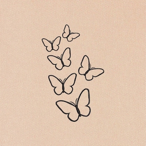 May include: A collection of six black butterfly outlines arranged diagonally on a light peach-colored textured background. The butterflies vary in size, with their wings spread open.