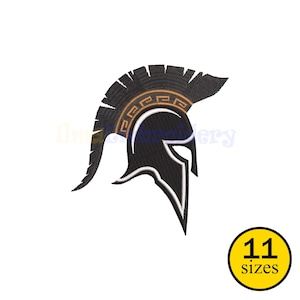 Puede incluir: Diseño de casco espartano en blanco y negro con un acento dorado en la cresta. La imagen incluye un círculo amarillo con el texto "11 tamaños". El casco es un símbolo clásico de fuerza y coraje.