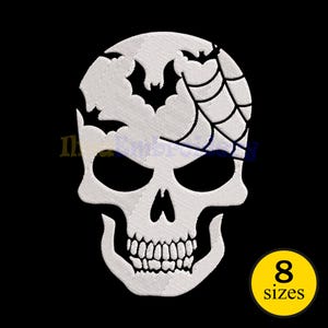May include: White embroidered skull patch with black details, including bats and a spiderweb design. The skull has large eye sockets and a detailed jawline. A yellow circle with the text "8 sizes" is in the lower right corner. Ideal for Halloween.