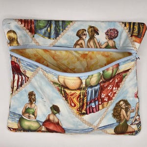 May include: A rectangular fabric pouch with a light blue zipper closure. The exterior features a repeating print of illustrated figures relaxing on a beach, accented by a decorative beige chain-link pattern. The interior lining is a warm orange.