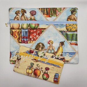 May include: Two rectangular fabric pouches featuring a repeating print of people at the beach. The larger pouch has a light blue zipper, while the smaller pouch has a yellow zipper and the text Project Bag set 3 printed across the front surface.