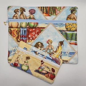May include: Two rectangular fabric zipper pouches featuring a quilted texture and a colorful beach scene print. The design displays various figures relaxing on a sandy shore with blue water and sky. The text Project Bag Set 4 is printed in white.