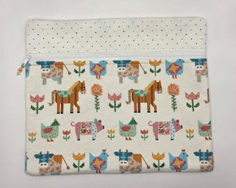 May include: A rectangular quilted fabric pouch featuring a repeating pattern of stylized farm animals including cows, horses, pigs, and chickens interspersed with colorful flowers on a cream background, finished with a white zipper and polka dot trim.