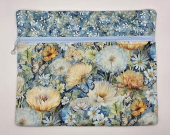 May include: A rectangular fabric pouch featuring a light blue zipper closure. The exterior displays a detailed botanical print with yellow and white flowers, dandelion seed heads, green foliage, and several butterflies in blue and white.