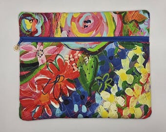 May include: A rectangular zippered pouch featuring a vibrant, multi-colored floral pattern with painted brushstroke textures in shades of red, pink, yellow, blue, and green. The pouch has a bright blue zipper closure with a small gold sun charm.