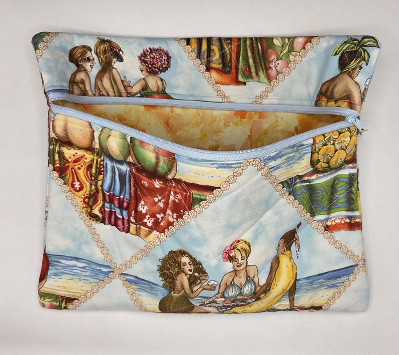 May include: A quilted fabric pouch featuring a light blue zipper and a repeating beach scene print. The pattern displays various figures in swimwear, tropical foliage, and ocean waves, all interconnected by a decorative beige chain-link motif.