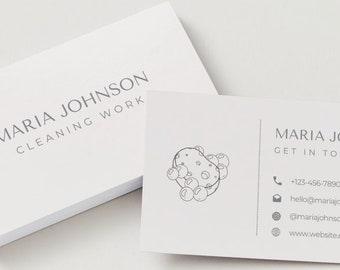 May include: A white business card with black text that reads "MARIA JOHNSON CLEANING WORK" on the front. The back of the card has a black and white illustration of a sponge with bubbles and the text "MARIA JO GET IN TO" followed by contact information including a phone number, email address, social media handle, and website address.