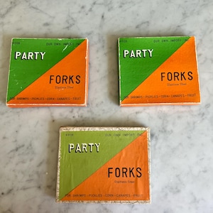 Może przedstawiać: Trzy pudełka Party Forks, wykonane ze stali nierdzewnej. Pudełka są pomarańczowe i zielone z napisem "Party Forks" w kolorze czarnym. Pudełka są oznaczone "Our Own Import Inc." i mają nadrukowany numer "#5106". Pudełka są przeznaczone do krewetek, ogórków kiszonych, kukurydzy, kanapek i owoców.