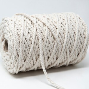 May include: A roll of natural white cotton rope, ideal for crafting, macrame, or home decor projects.