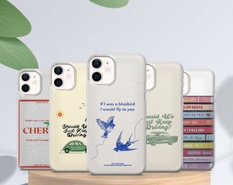 May include: Five different iPhone cases with various designs. The cases are clear and show the phone's camera lens. The designs include a vintage car, a bluebird, a quote about driving, and a stack of colourful cassette tapes.
