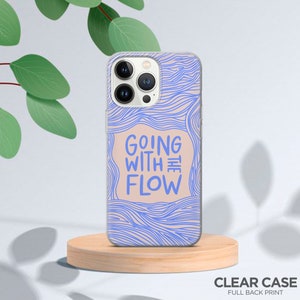 以下が含まれることがあります： 青い波状の線と「Going with the Flow」というテキストが全面に印刷された透明な携帯電話ケース。