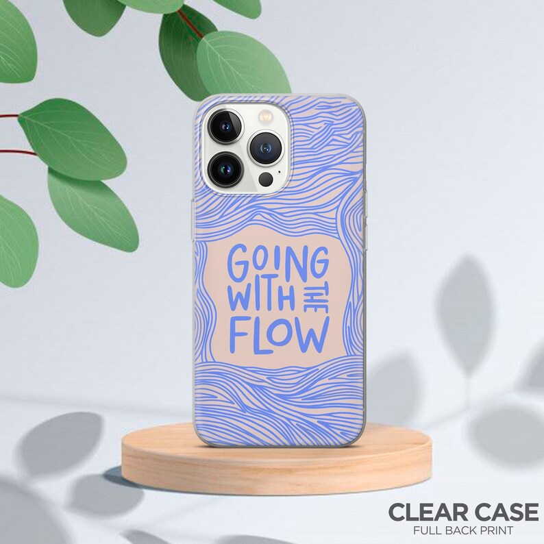 以下が含まれることがあります： 青い波状の線と「Going with the Flow」というテキストが全面に印刷された透明な携帯電話ケース。
