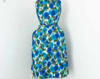 May include: A sleeveless dress with a white background and a blue and green floral pattern. The dress has a fitted bodice and a full skirt.