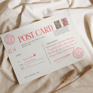 Puede incluir: Una postal del Día de San Valentín con texto y sellos rojos. La postal dice "POST CARD" e incluye un mensaje escrito a mano. La fecha "02.14" está impresa en la esquina. Espigas de trigo en primer plano.