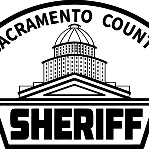 May include: Black and white illustration of a building with a dome, with the text "Sacramento County Sheriff" around the top and bottom.