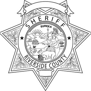May include: Black and white illustration of a sheriff's badge with a five-pointed star, a circle with the words "SHERIFF" and "RIVERSIDE COUNTY" around it, and a smaller circle inside with the words "EUREKA" and a scene of a woman standing on a mountain with a bear and a boat in the water.