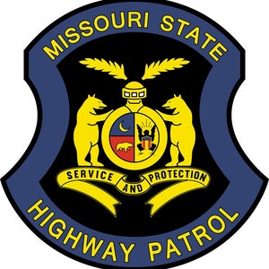 Puede incluir: Una insignia azul y amarilla con las palabras "Missouri State Highway Patrol" y "Service and Protection" sobre un fondo negro. La insignia presenta un escudo con dos osos, una luna creciente y una estrella.