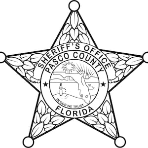 May include: Black and white illustration of a sheriff's star badge with the words "Sheriff's Office Pasco County Florida" and "In God We Trust" around the perimeter.