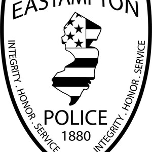 May include: Black and white shield-shaped emblem with the words "Eastampton Police" and "Integrity. Honor. Service" surrounding a stylized outline of the state of New Jersey with stars and stripes. The year "1880" is printed below the state outline.