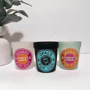 May include: Three personalized white, black, and light green cups with a paw print design and the text "Pup Cup" and "Dunkie's Junkie".