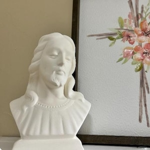 May include: White ceramic bust of a person with long hair and a beard. The bust is unfinished and ready to be painted.