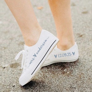 May include: White canvas sneakers with blue text that says "mrs. ♥ anderson" on one shoe and "♥ 12.09.25 ♥" on the other shoe.