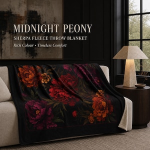 May include: A black sherpa fleece throw blanket featuring a floral pattern of red, orange, and purple peonies. The text on the image reads: MIDNIGHT PEONY SHERPA FLEECE THROW BLANKET Rich Colour • Timeless Comfort. The blanket has a soft, light-coloured lining.