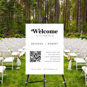 May include: A white sign with black text and a QR code announcing the wedding of Brianna and Robert. The sign reads "Welcome to the wedding of Brianna + Robert. Please scan this QR code with your smartphone to view our wedding program. 05.05.20XX | Los Angeles, CA."