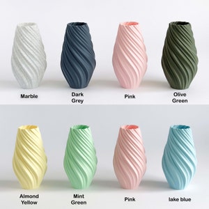 May include: Eight ceramic vases in various colors, including marble, dark grey, pink, olive green, almond yellow, mint green, lake blue, and pink. The vases are all the same shape, with a twisted, swirling design.