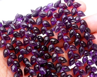 May include: A strand of amethyst gemstone beads in a teardrop shape. The beads are a deep purple color and have a faceted finish.