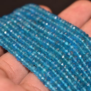 May include: A strand of blue topaz gemstone beads. The beads are faceted and have a light blue color. The beads are strung on a thread and are ready to be used for jewelry making.