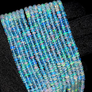 May include: A strand of iridescent opal beads, with a mix of blue, white, and pink hues. The beads are small and round, and they are strung together on a clear thread.